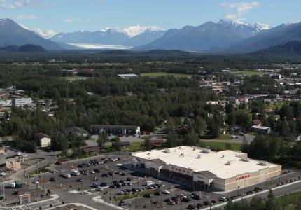 Arial view of Palmer AK buildings with snow capped mountains in the distance.