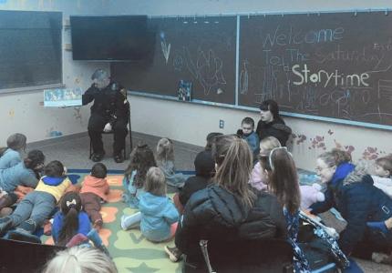 A police officer reading a book to a group of children