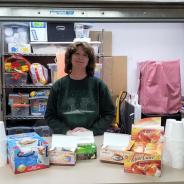 volunteer standing at concession window with snacks for guests