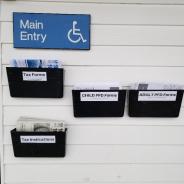 PFD and tax forms displayed on wall with a "Main Entry" handicap sign