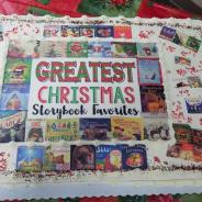 A cake with pictures of books printed on top and the words "Greatest Christmas Storybook Favorites"