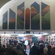 A Celtic band in the library with a large crowd watching them perform
