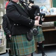 A man in Scottish dress plays bagpipes