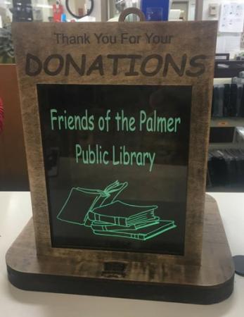 A donation box with a plaque that reads "Thank you for your donations" and "Friends of the Palmer Public Library"
