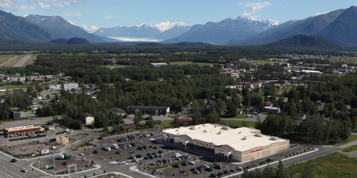 Arial view of Palmer AK buildings with snow capped mountains in the distance.