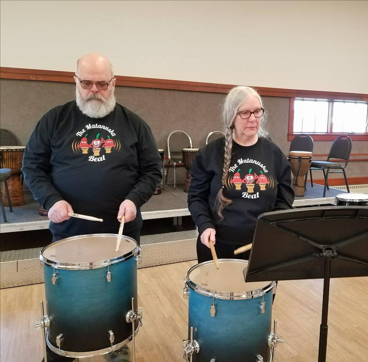 A man and a woman playing drums